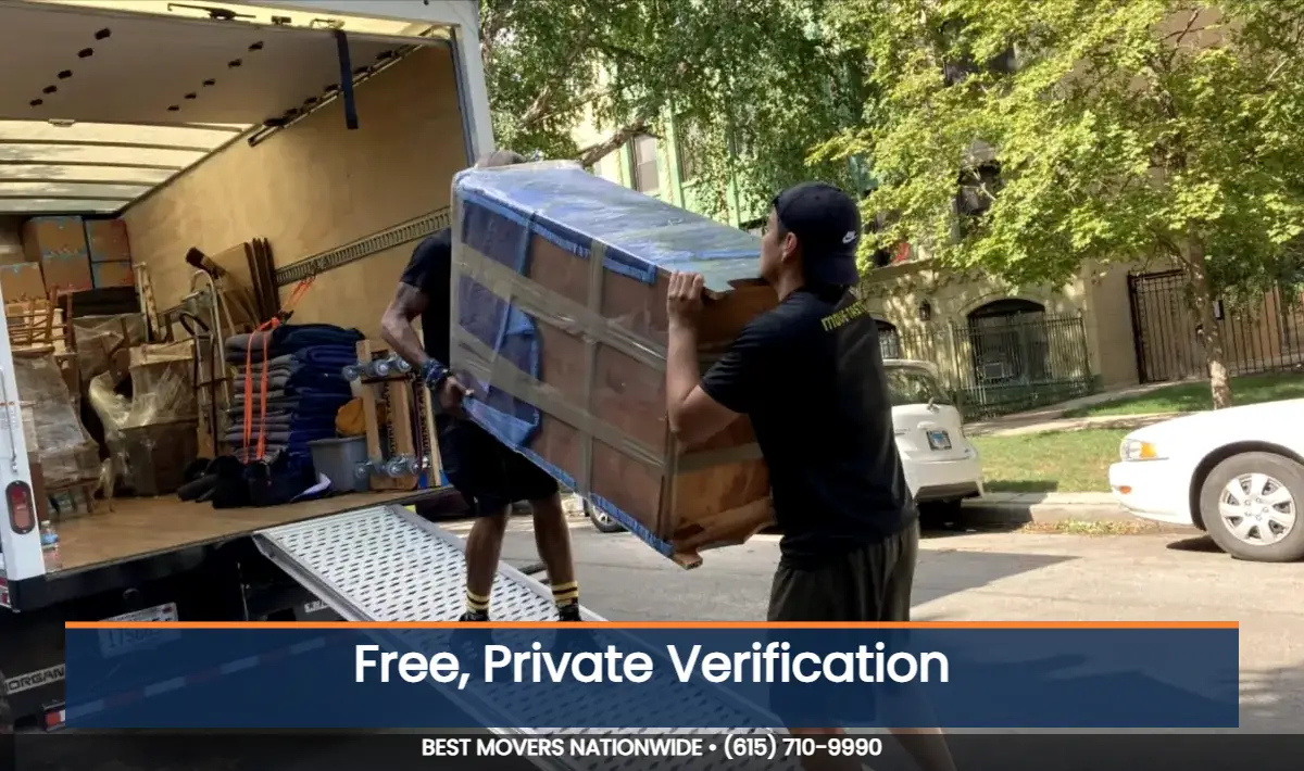 JM Moving crew carrying a wrapped item down a truck ramp